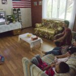 A family watching a film together on a living-room television