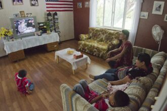 A family watching a film together on a living-room television